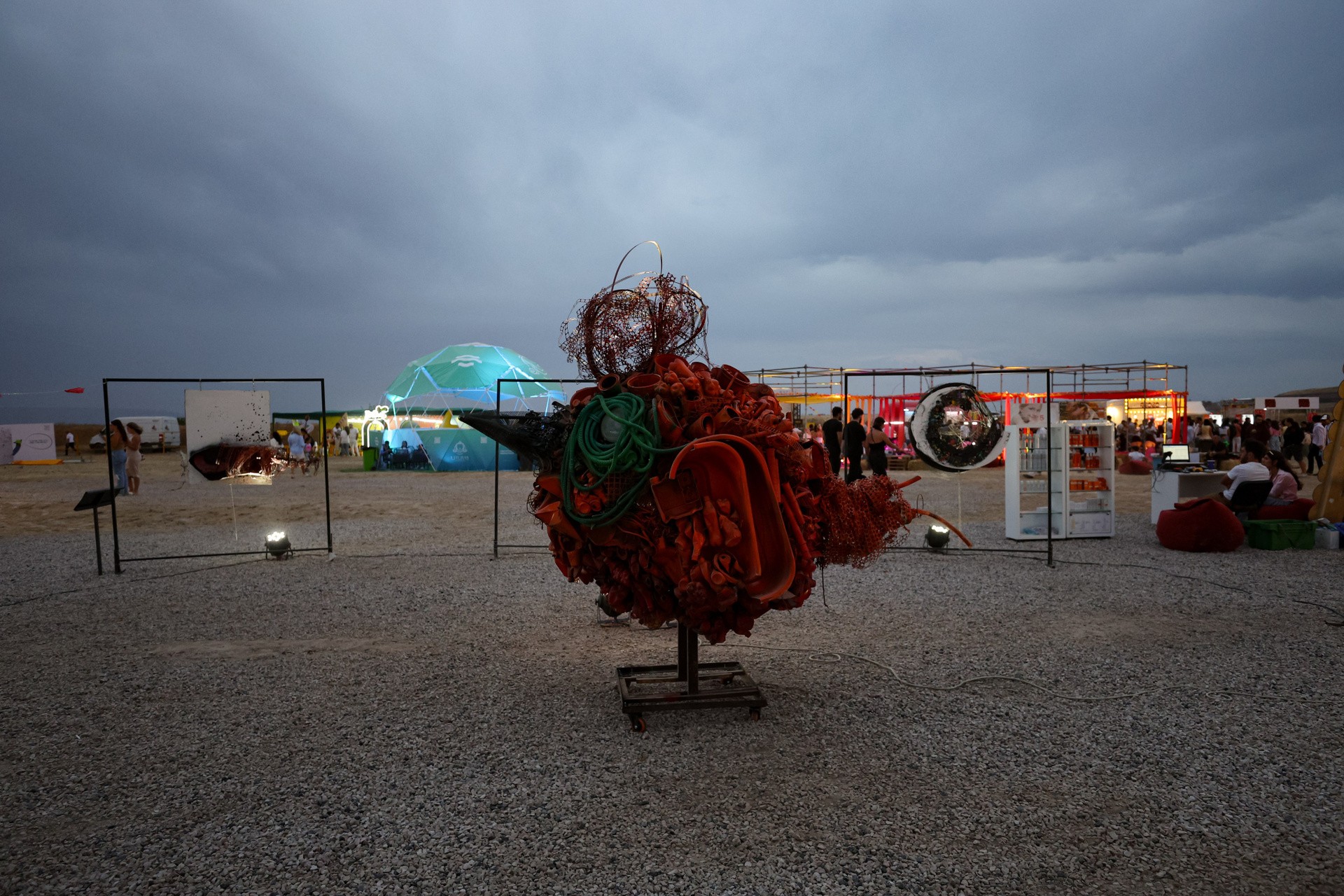 Recycled-materials sculpture installation at dusk