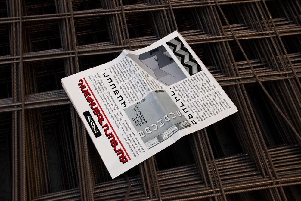 Newsletter layout mockup resting on construction rebar